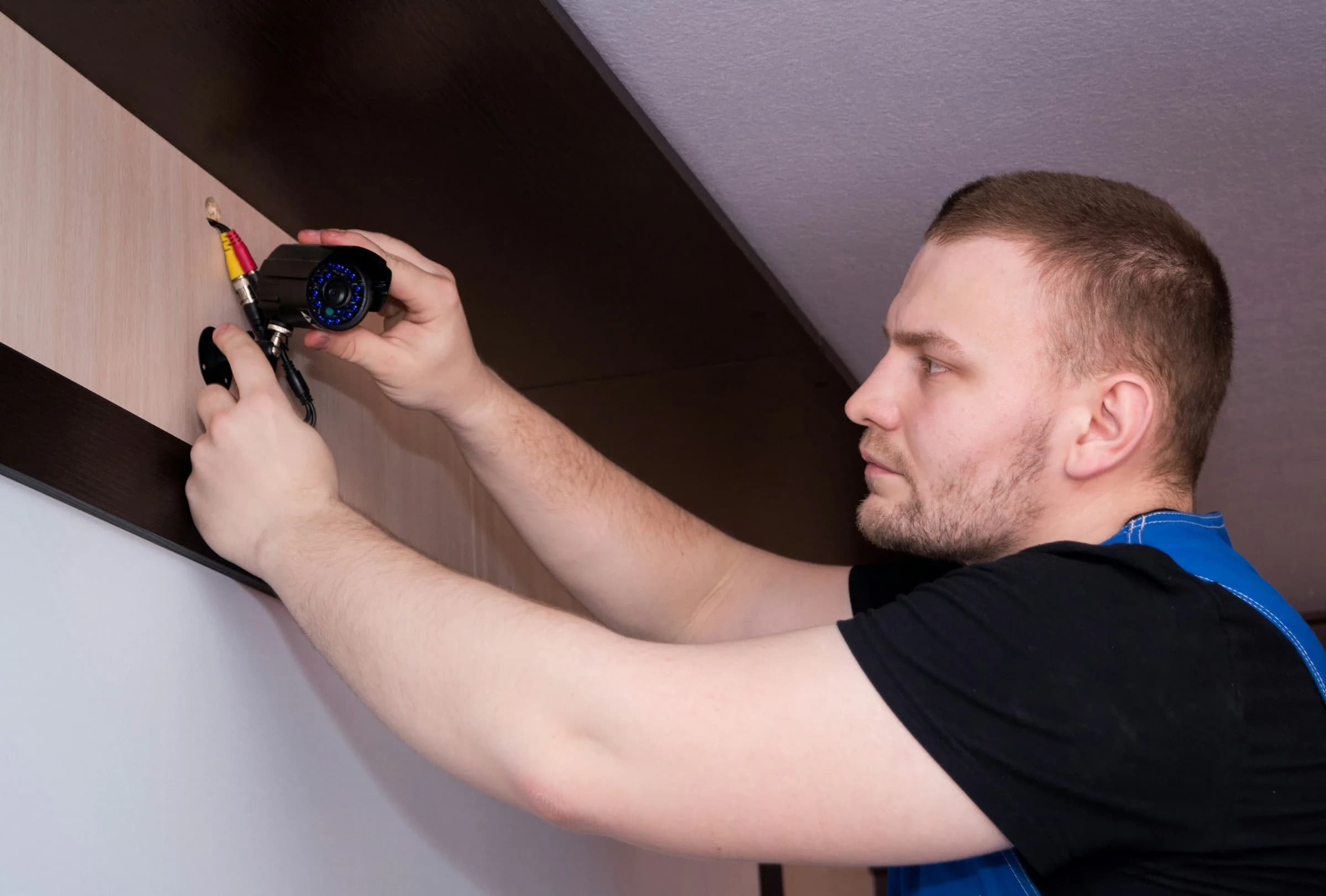 Technician installing a professional surveillance camera