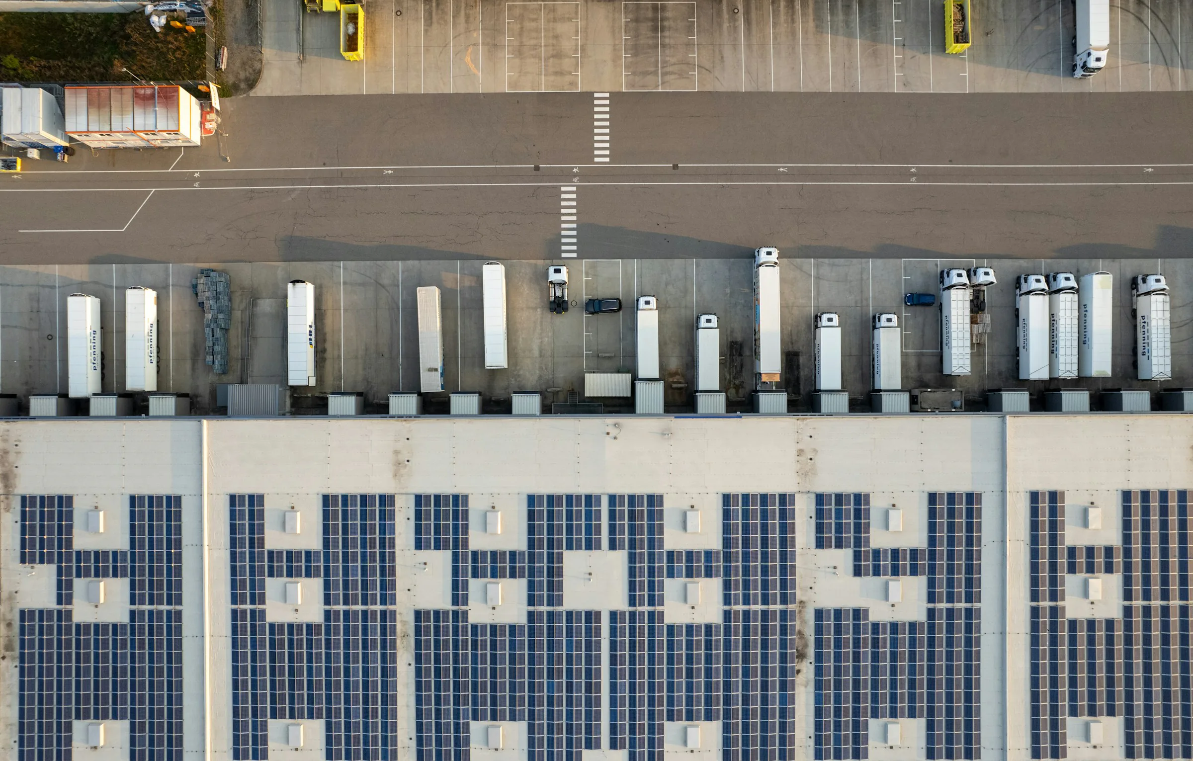 Aerial view of an active warehouse, its loading yard, and surrounding access roads