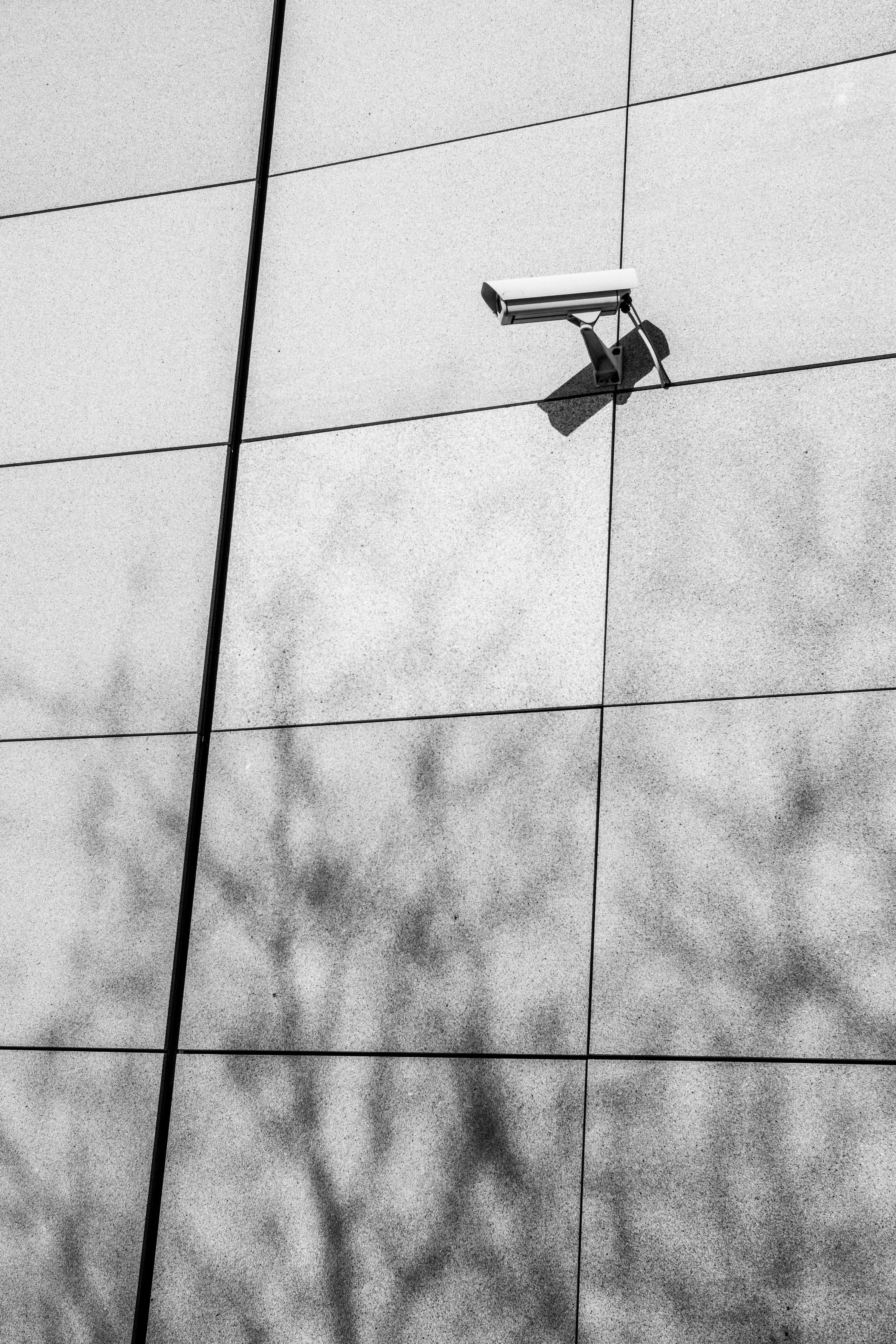 A surveillance camera mounted within the architecture of a commercial property